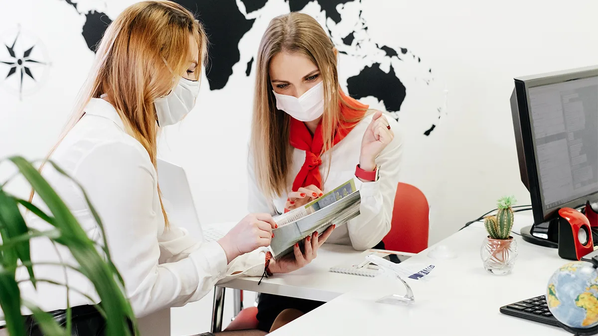 Reisebüro Maske Expedient Kunde Beratung Foto iStock ninelutsk Reisebüro Maske Expedient Kunde Beratung Foto iStock ninelutsk.jpg