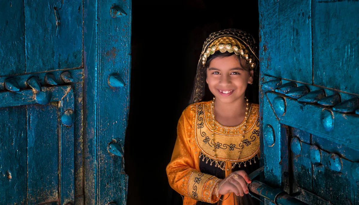 f6bb1a5cfbc8-Omani-girl-opening-door-C-Ministry-of-Heritage-Tourism-Sultanate-of-Oman Mädchen Oman tradition
