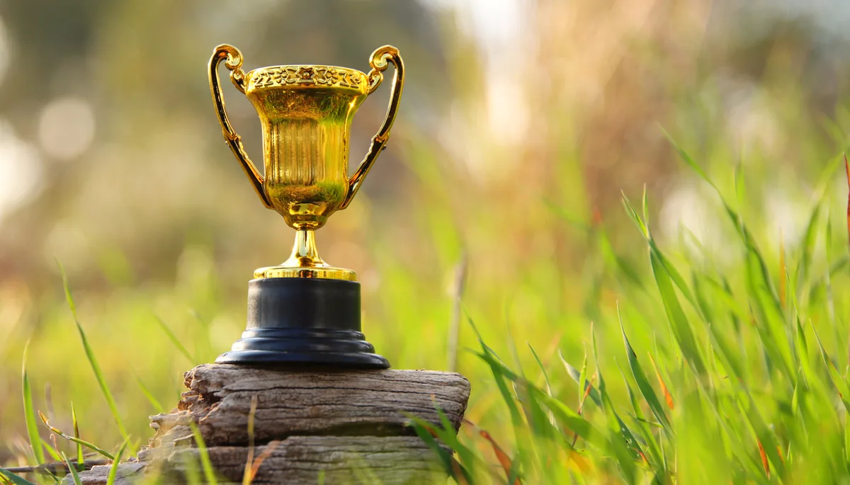 Golden trophy in nature. Concept of quality, and ecofriendly award Nachhaltigkeit Pokal In Berlin trifft sich die Branche zum Greensign Future Lab. Im Rahmen der Veranstaltung wird auch der Green Monarch Award verliehen.