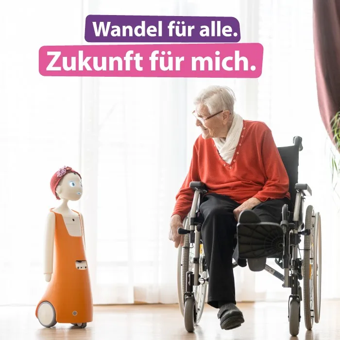 fd20bb373d97-Roboter-mit-Bewohnerin-im-Rollstuhl-Evangelische-Bank Roboter mit Bewohnerin im Rollstuhl Evangelische Bank.jpg