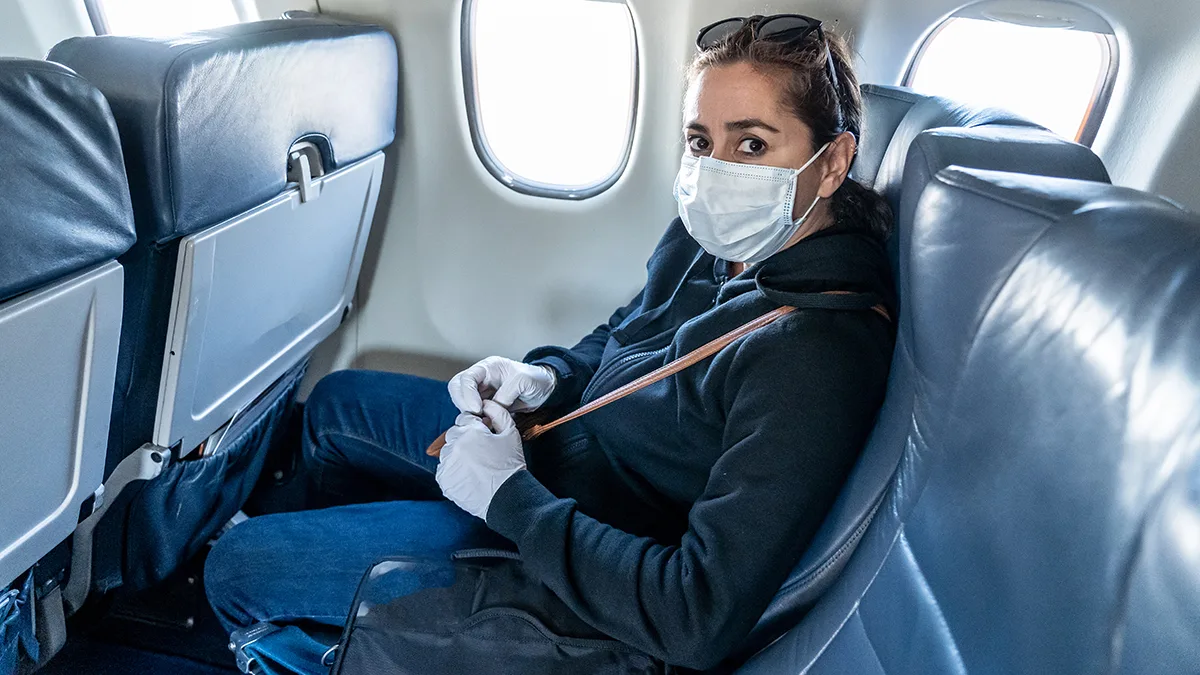 Flugzeug Passagierin mit Maske Foto iStock Sam Thomas Flugzeug Passagierin mit Maske Foto iStock Sam Thomas