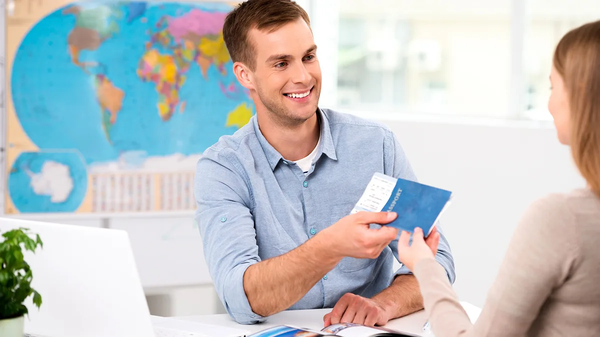 Reisebüro Expedient überreicht Ticket und Pass Foto iStock dima_sidelnikov Reisebüro Expedient überreicht Ticket und Pass Foto iStock dima_sidelnikov.jpg