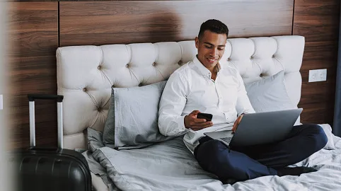 93235d097a99-iStock-1157979674 Hotelzimmer Laptop Bett Geschäftsreise